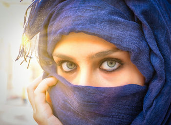 Close-up portrait of woman covering face with scarf