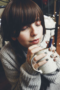 Portrait of young woman drinking coffee