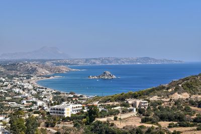 Scenic view of sea and buildings against clear sky