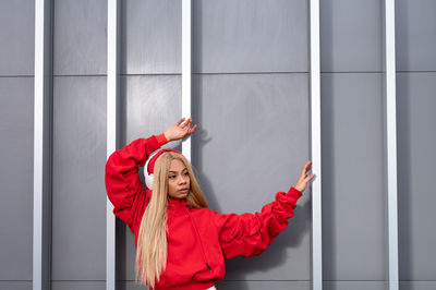 Cheerful african american woman with long blonde hair wearing sportswear and wearing headphones