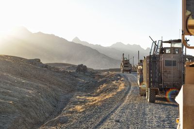 Road leading towards mountains against clear sky