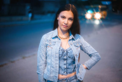 Portrait of beautiful young woman standing at night