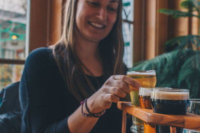 Close-up of a smiling young woman drinking drink