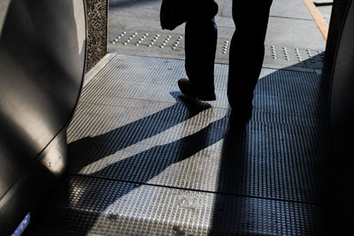 Low section of man walking by escalator