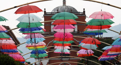 Multi colored umbrellas hanging outside building against sky