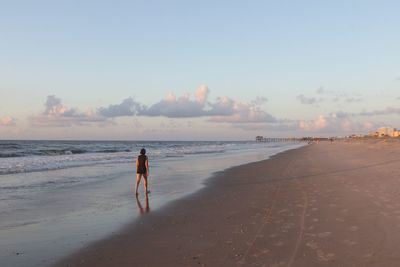 Woman on beach against sky