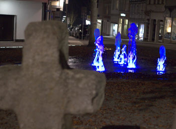 Group of people by illuminated lighting equipment at night