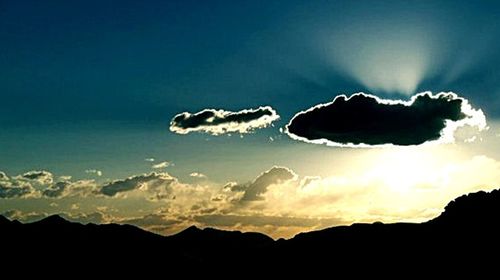 Scenic view of silhouette mountains against dramatic sky