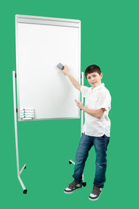 Full length portrait of boy standing against blue background