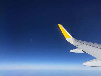 Airplane wing against clear blue sky