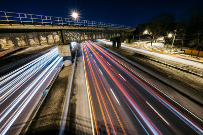 Light trails on bridge in city at night