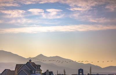 Buildings and mountains against sky during sunset