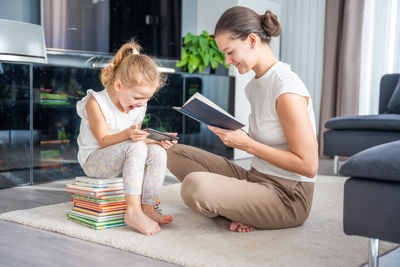 Young woman using laptop while sitting on sofa at home