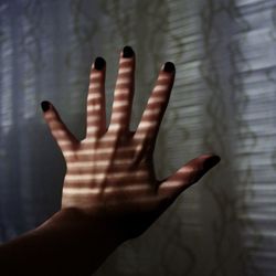 Cropped hand of woman against wall