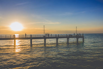 Pier on sea at sunset