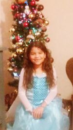 Portrait of smiling girl standing against wall