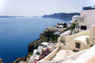 Houses by sea against sky in city