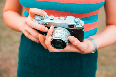 Midsection of woman holding camera