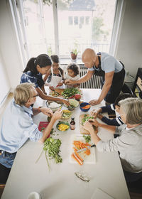 High angle view of multi-ethnic family preparing asian food at table