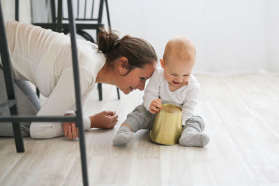 Mom and baby playing together on the kitchen floor, living style