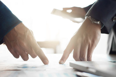 Close-up of man holding hands on table