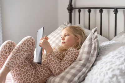 Cute girl using digital tablet at home