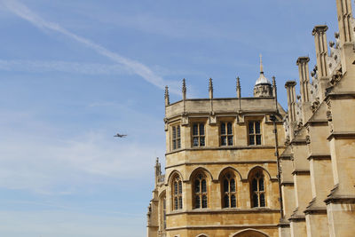 View of an aeroplane on sky with the st george's chapel in windsor castle on a sunny day