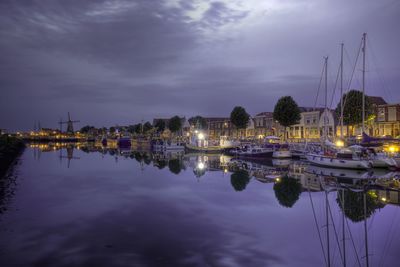 Sailboats in marina at harbor against sky