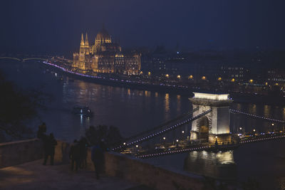 Illuminated city against sky at night