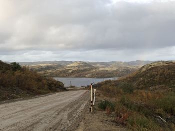 Road leading towards mountains against sky