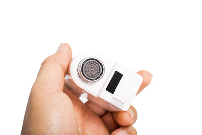 Close-up of hand holding camera over white background