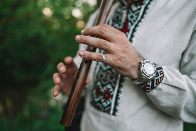 Midsection of man playing musical instrument