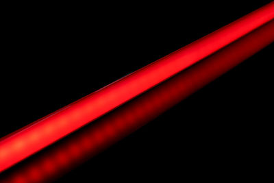 Close-up of illuminated lighting equipment against black background