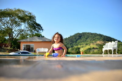 Portrait of a smiling girl against built structure