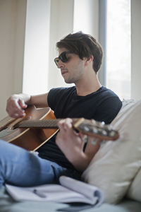 Young musician writing songs on an acoustic guitar