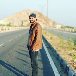 Portrait of young man standing on road