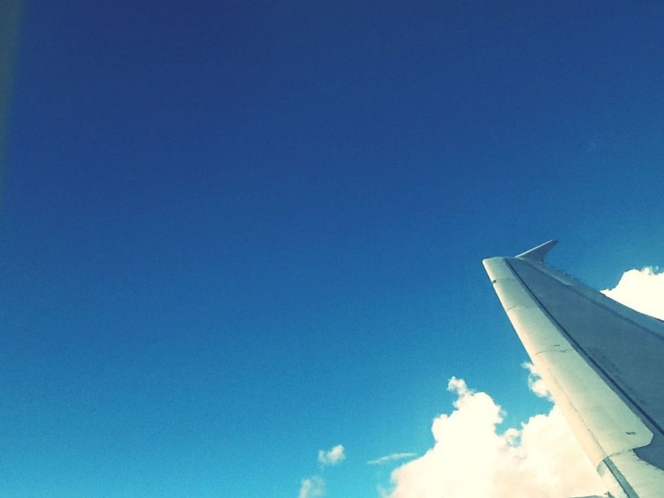 blue, low angle view, flying, airplane, air vehicle, sky, part of, copy space, clear sky, transportation, cropped, mid-air, vapor trail, mode of transport, aircraft wing, cloud - sky, nature, day, outdoors, no people