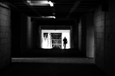 Man walking in illuminated tunnel