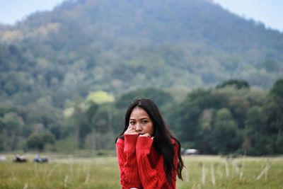 Portrait of young woman standing on field