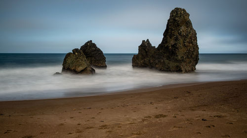 Rocks on beach against sky