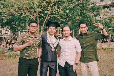 Portrait of young couple standing against plants
