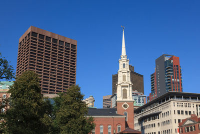 Low angle view of buildings against clear blue sky