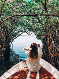 Rear view of woman sitting by plants