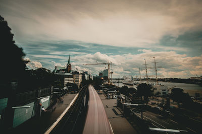 Cars on road in city against sky