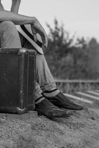 Low section of man sitting on street