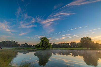 Scenic view of lake against sky at sunset