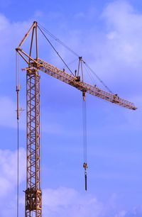 Low angle view of crane against sky