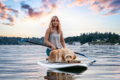 Woman with dog against sky