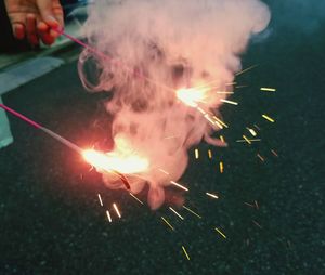 Cropped image of woman holding sparklers