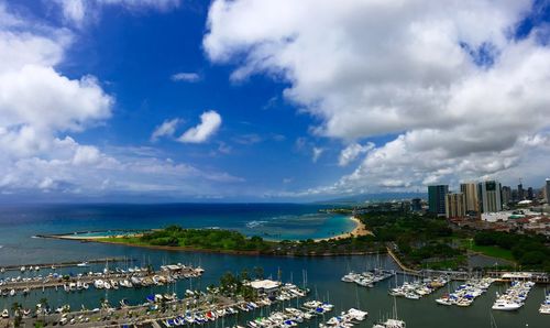 High angle view of sea by cityscape against sky